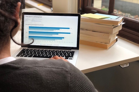 A woman reviews documents on a laptop