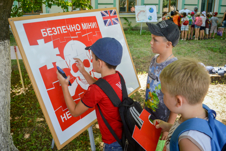 children looking at a diagram about mines in Ukraine