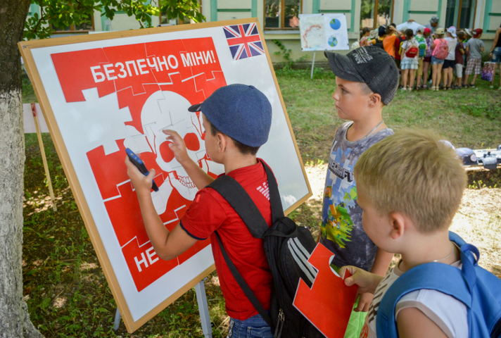 children looking at a diagram about mines in Ukraine