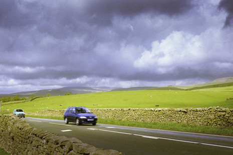Photo of cars driving on a rural road