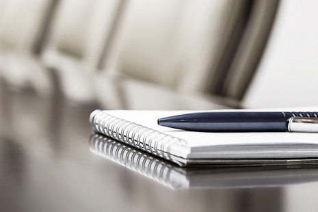 a notebook and pen on a boardroom table