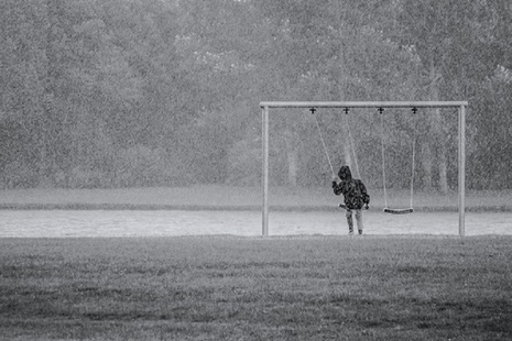 child playing outside in the rain