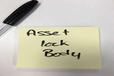 The words asset locked body on a post it note