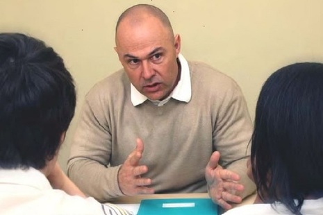Man at desk talking to two people