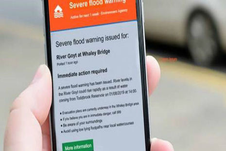 Close up of a smart phone with a flood warning on the screen for the River Goyt at Whaley Bridge