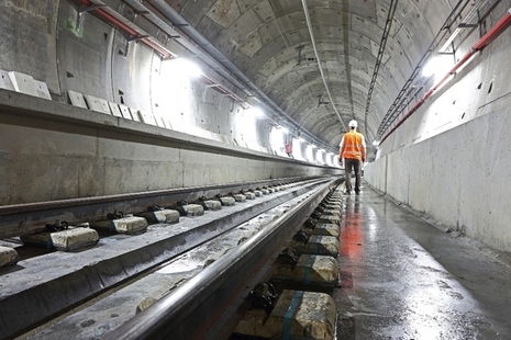workman walking through a rail tunnel