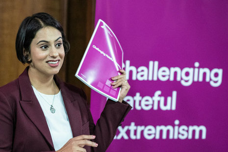 Sara Khan holding a copy of the report "Challenging hateful extremism"