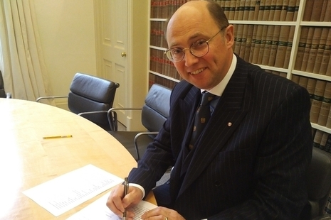 An image of Mark Watson-Gandy signing a document