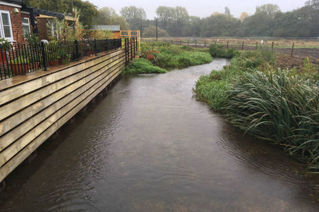 House with completed flood wall next to a river