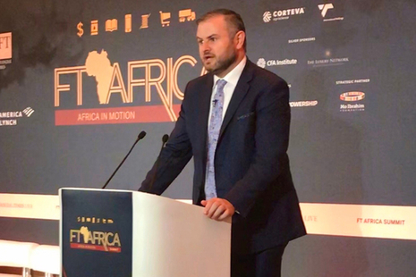 Andrew Stephenson, Minister for Africa, at a podium doing a speech
