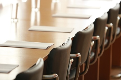 Boardroom with chairs, paper and glasses of water