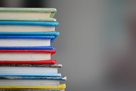 A pile of different-coloured hardback books