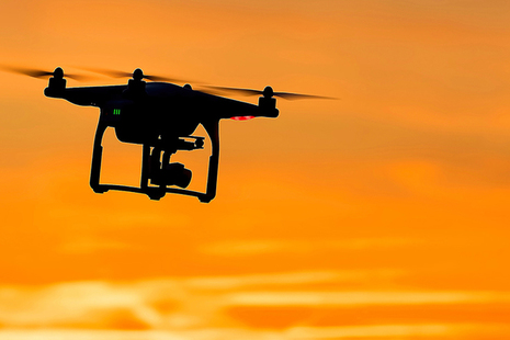 Drone silhouetted against sunlit sky