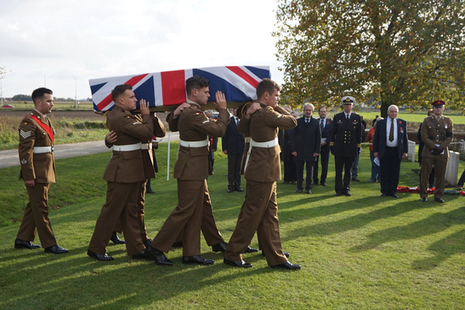 The bearer party carry the coffin of the unknown soldiers into New Irish Farm Cemetery.
