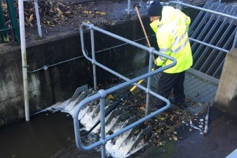 Environment Agency officer clearing debris from a screen