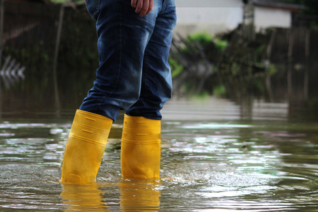 Person with yellow wellies standing in a flood