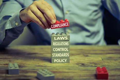 building blocks with compliance and regulation written on them.