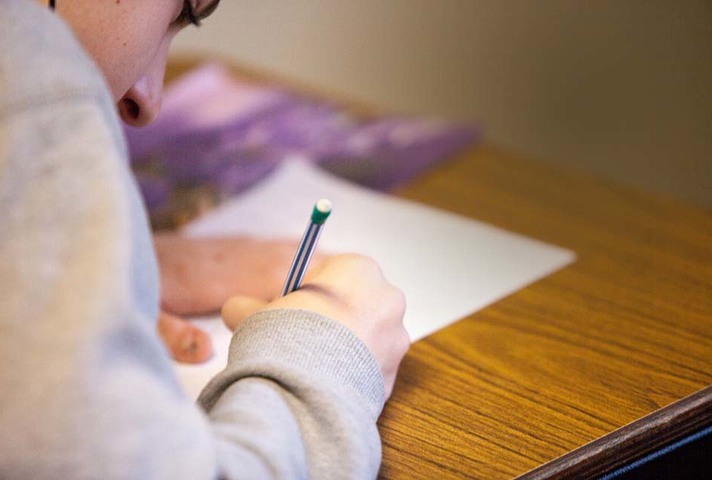 Girl sitting at a desk, pencil in hand
