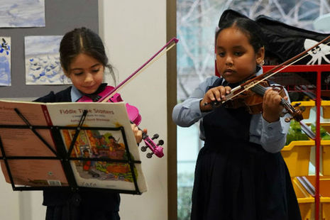 two young children playing the fiddle