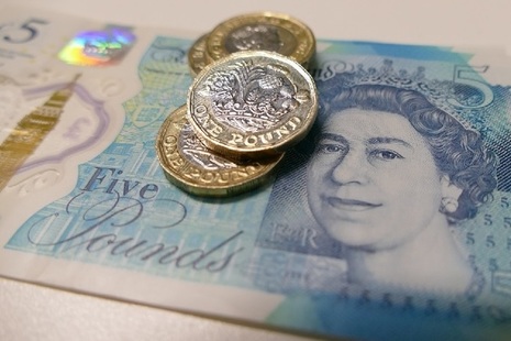 An image of pound coins and a five-pound note.