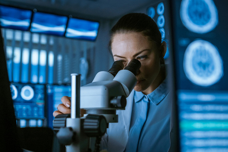 Female researcher using microscope