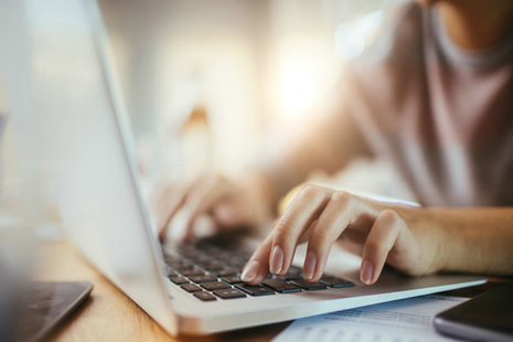 An image of a person typing on a laptop.