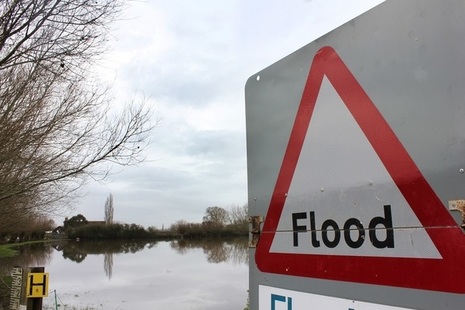 Flood sign overlooking flooded land in a rural area