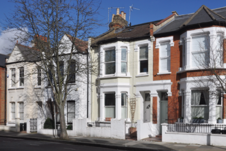 A terrace of small Victorian period town houses on Rainville Road in the Borough of Hammersmith and Fulham, London, UK.