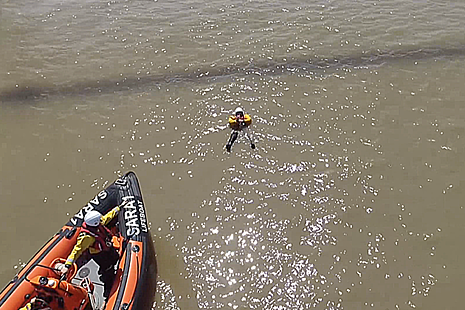 Aerial view of rescue boat approaching casualty on the water