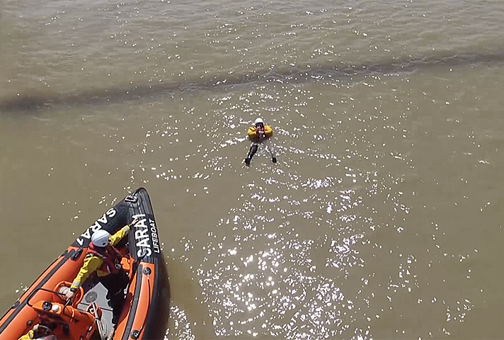 Aerial view of rescue boat approaching casualty on the water