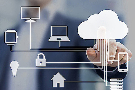 A man touches an image of a cloud on a screen covered with images representing a computer network.
