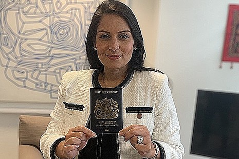 Home Secretary, Priti Patel, holding a blue passport