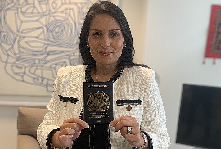 Home Secretary, Priti Patel, holding a blue passport