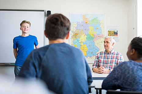 A child standing in front of other people talking