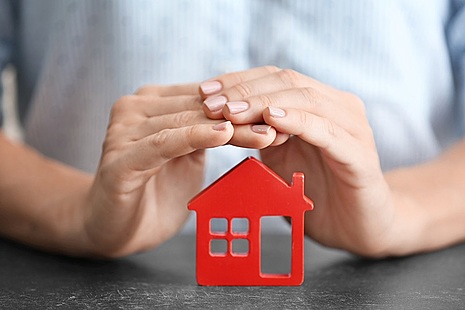 Photo of hands over house