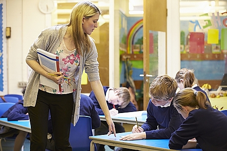 Image of a teacher and school children.