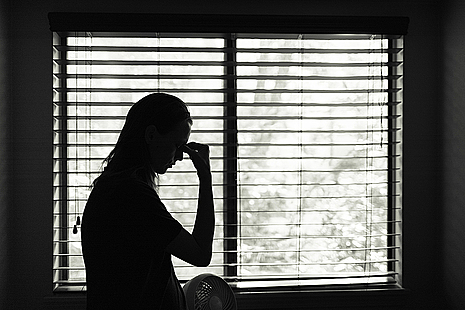 A silhouetted anonymous victim sitting down.