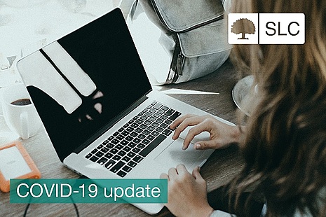 Image of a female student using a laptop with the words COVID-19 across it