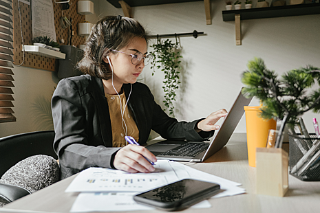 Woman sittig next to a table using a laptop