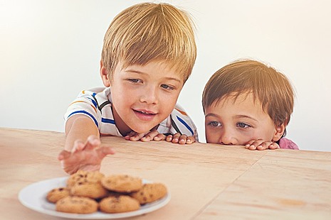 Children reaching for biscuits