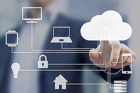 A man touches an image of a cloud on a screen covered with images representing a computer network.