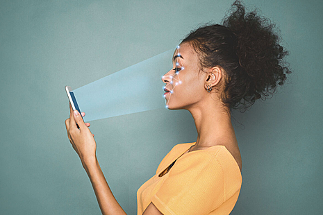 Woman scans face with mobile phone.
