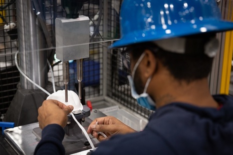 Close-up of a man making a face mask in a factory