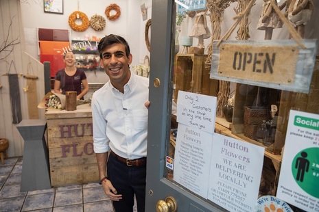The Chancellor standing at a shop entrance.