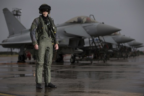 A pilot from 6 Squadron, RAF Lossiemouth, in front of a line of Typhoon aircraft in full flying attire.