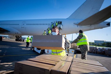 Soldiers unloading a PPE shipment from an aircraft