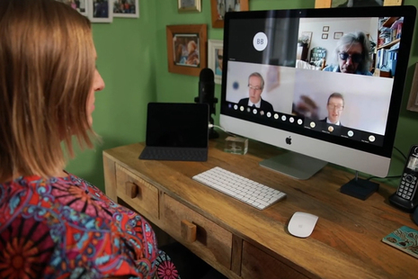 Woman watching virtual event on computer