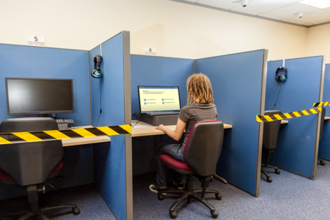Photo of a woman sat at a computer, answering a theory test question.
