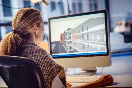 Woman in front of plan on computer screen