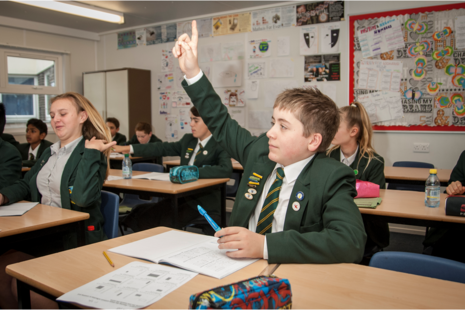 Male secondary student raising his hand.